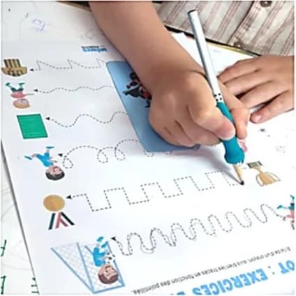 Main d’enfant, crayon équipé d’un grip bleu, suivant les chemins en pointillés d’une fiche de pré-graphisme.